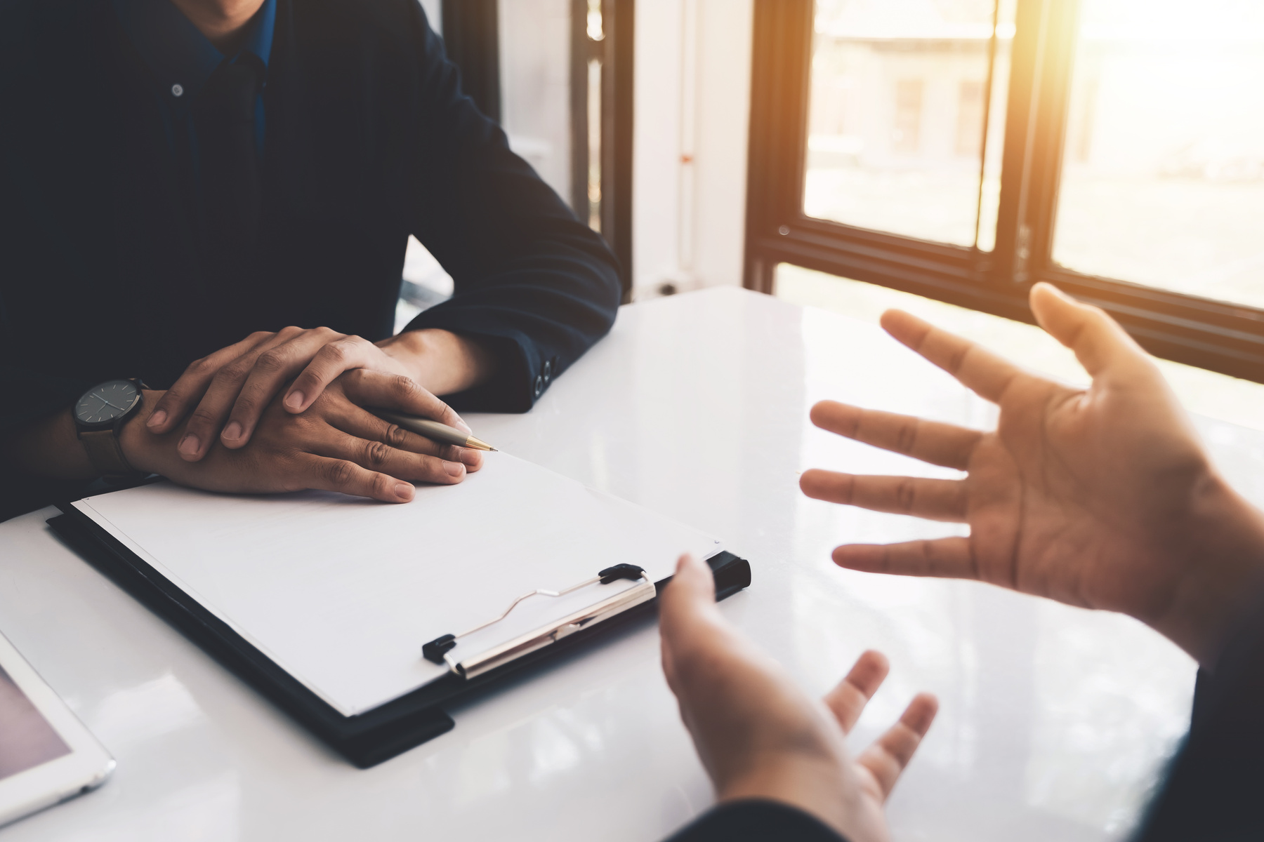 Close up of executive hand during interview. Examiner reading a resume during a job interview, employment and recruitment concept